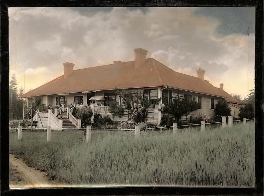 The historic lodge in an early hand-tinted photograph