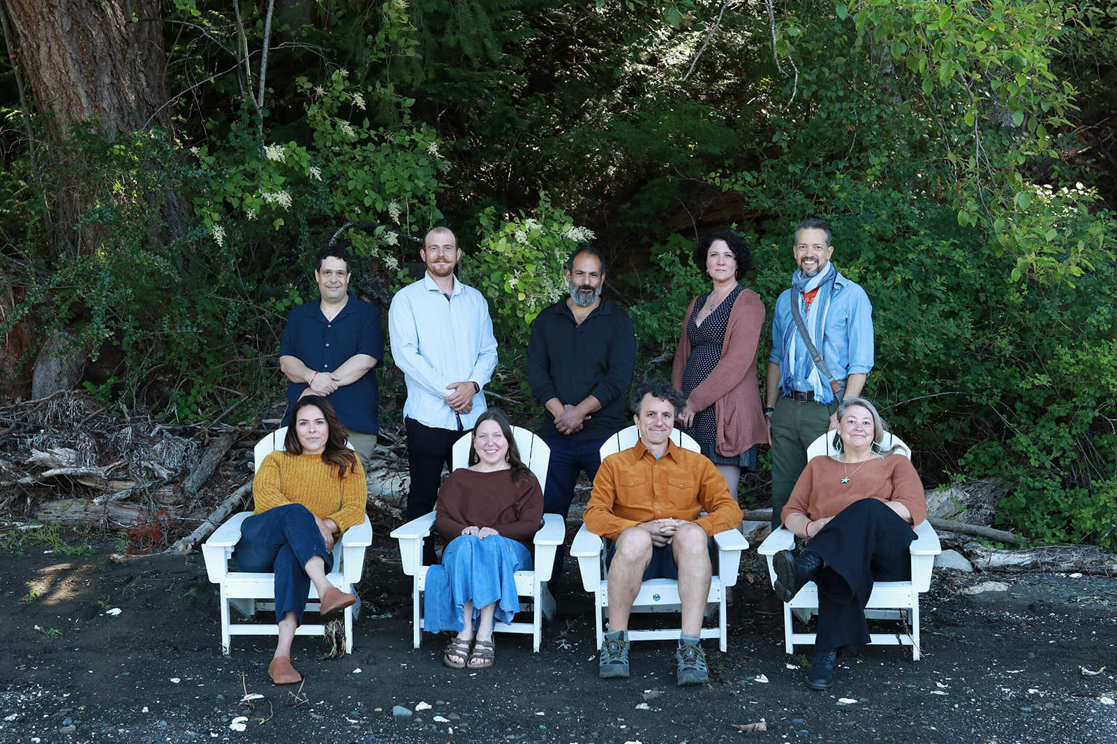 The Camp Denman team seated together on the beach