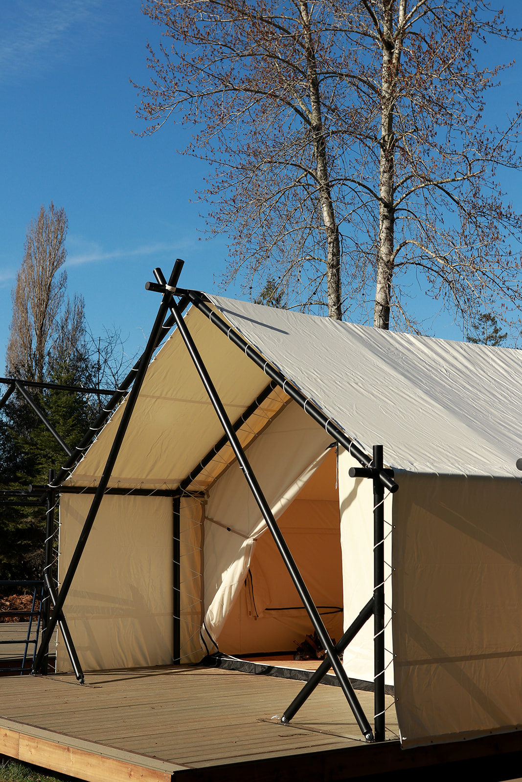 A view of the mountains and sea framed through the open canvas tent